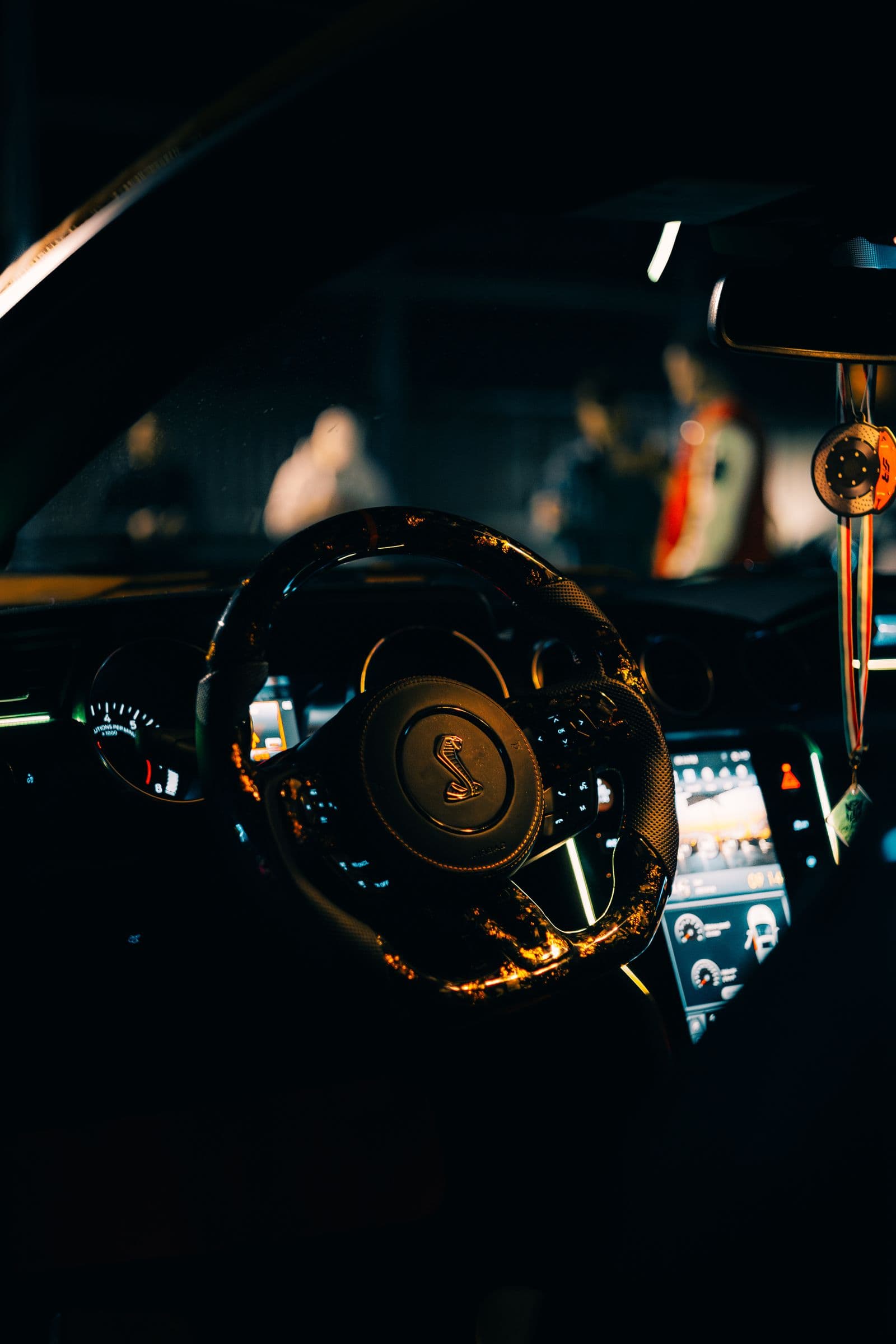 Steering wheel and dashboard of a luxury car glowing at night