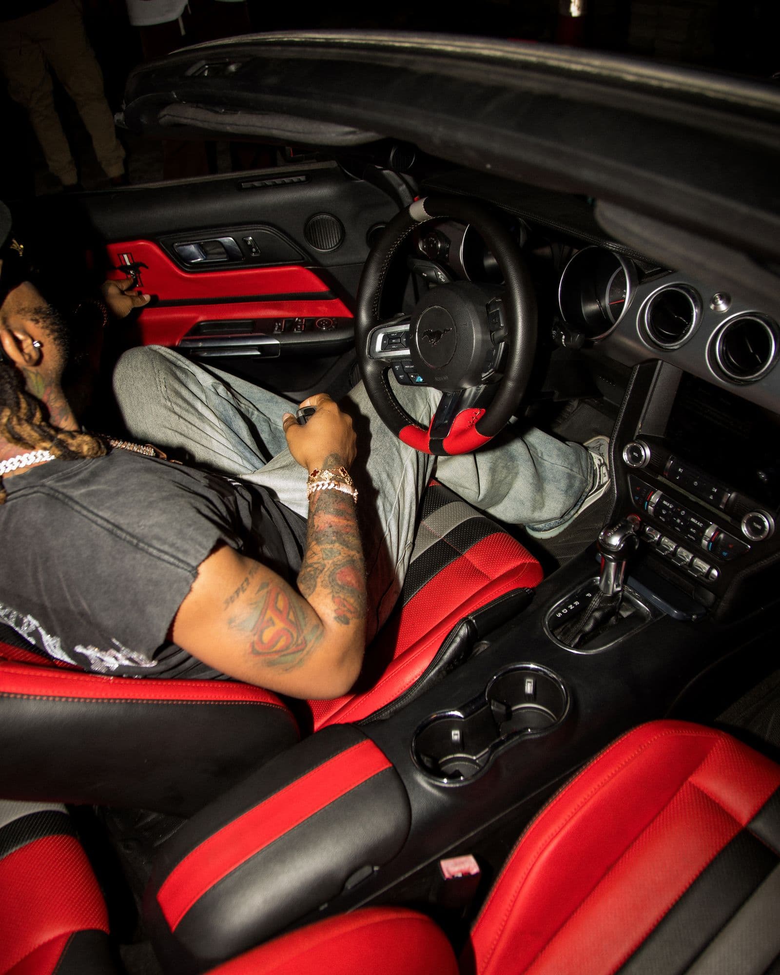 Driver in a sports car with red leather seats, shot from above