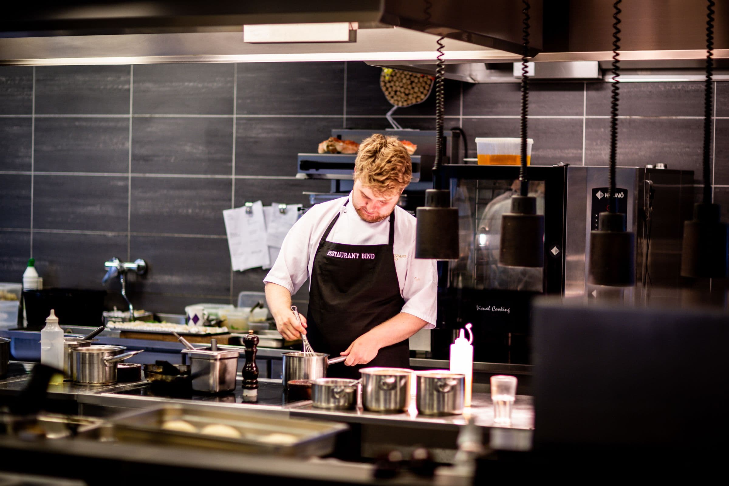 Chef cooking at the pass of a modern kitchen